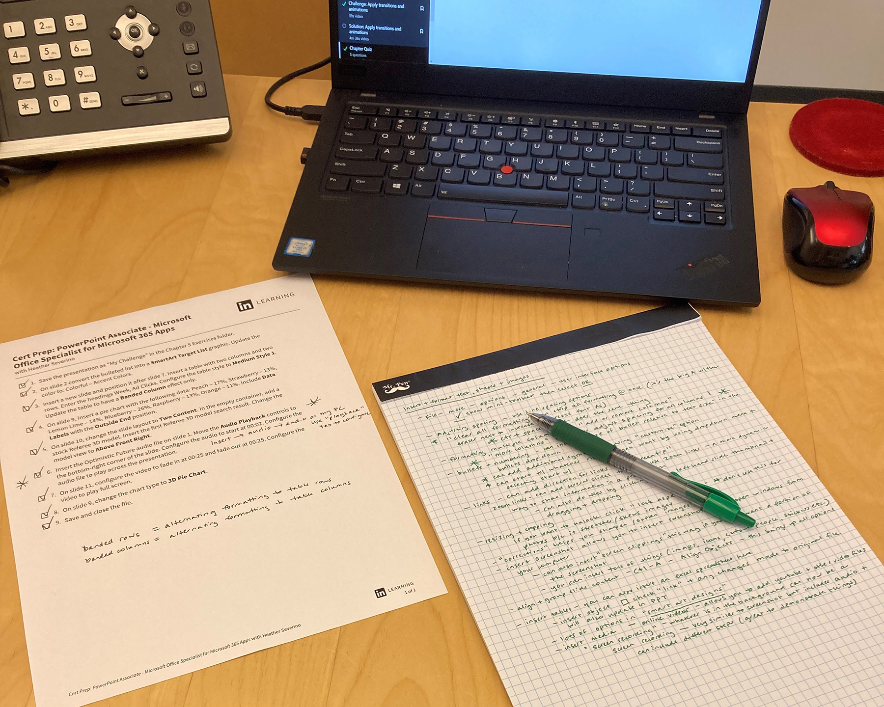 photo of desk with laptop, phone, worksheet, and handwritten notes